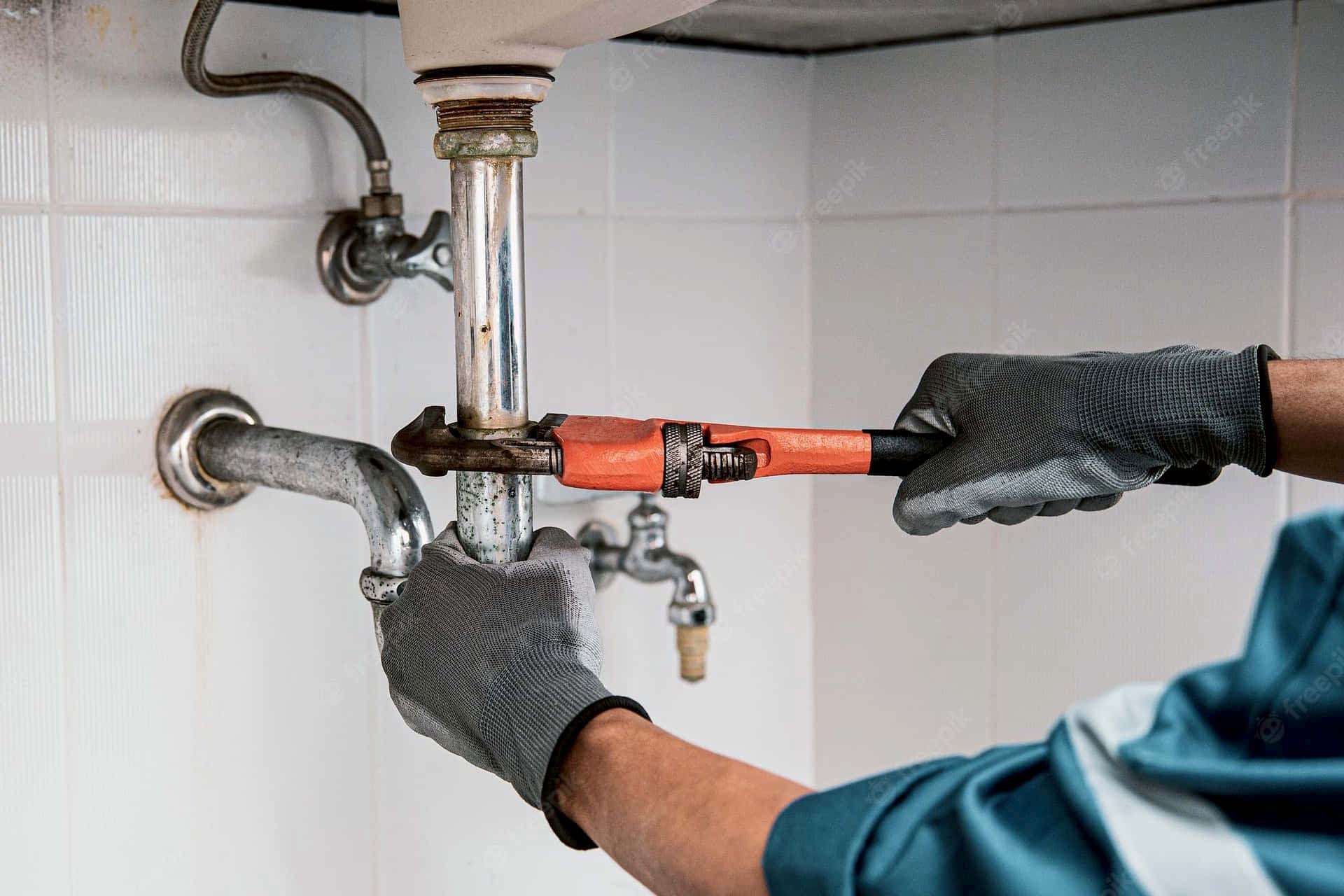Plumber working on pipes in a London kitchen