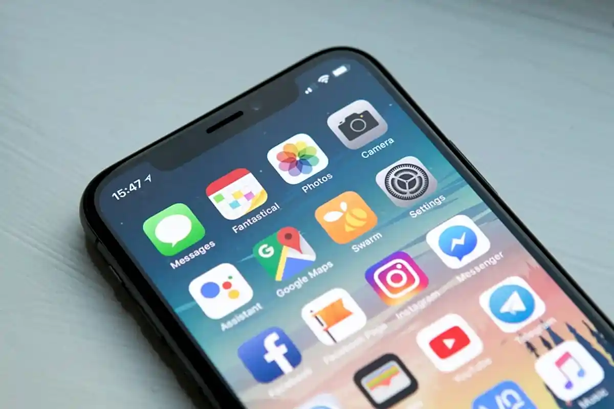 Developer reviewing iOS and Android mobile app interfaces on smartphone in London office