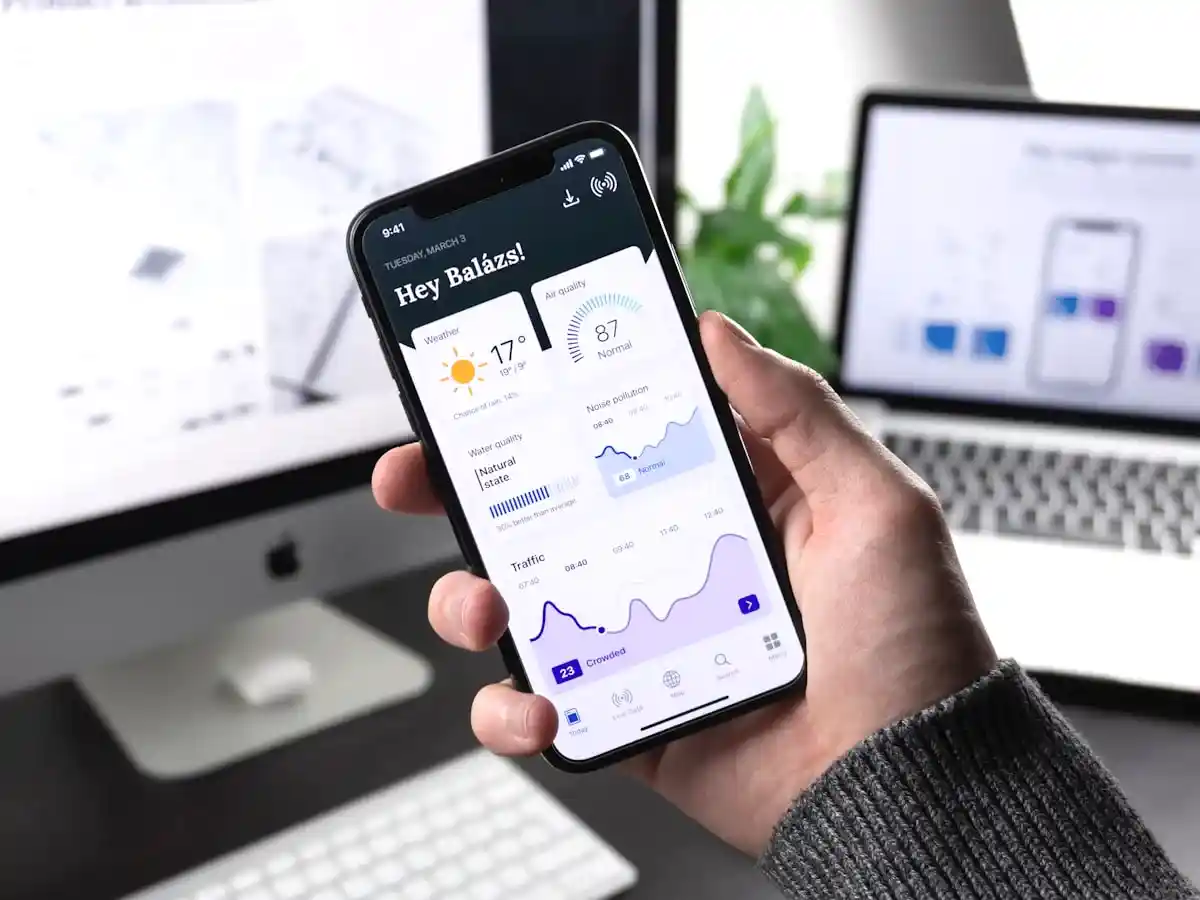 Developer reviewing mobile app interface on smartphone screen in professional London studio setting